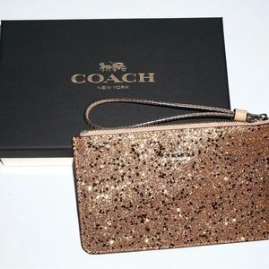 Coach wristlet with sparkles and stars. Rose gold with zipper and small pockets.